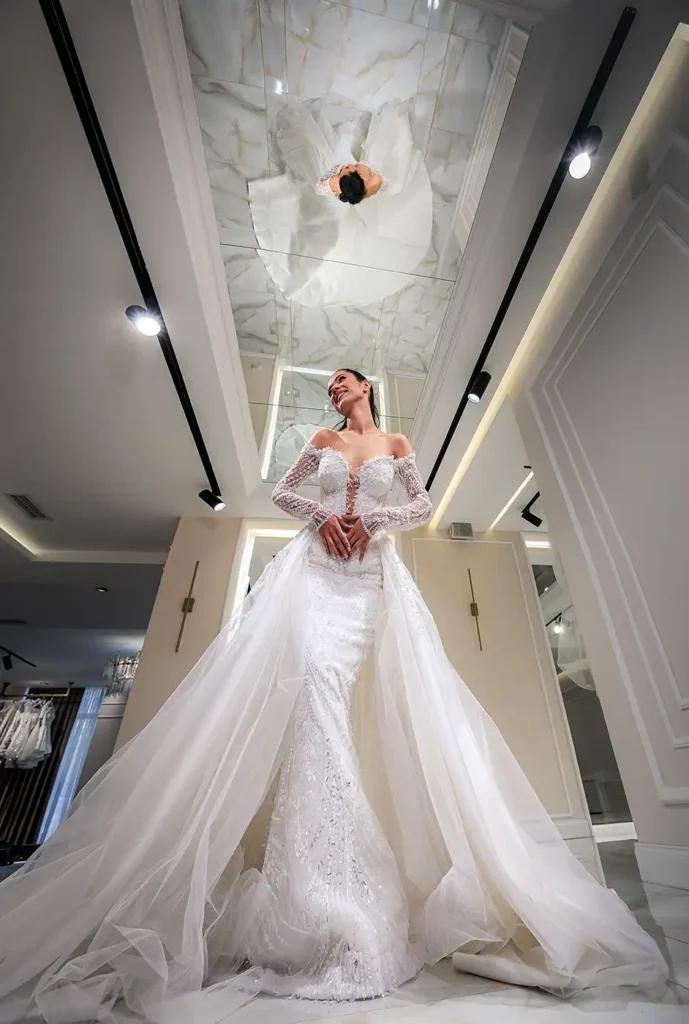 Mlada u venčanici fotografisana ultra-širokougaonim objektivom uz kreativnu upotrebu ogledala i perspektive u salonu venčanica u Beogradu.
